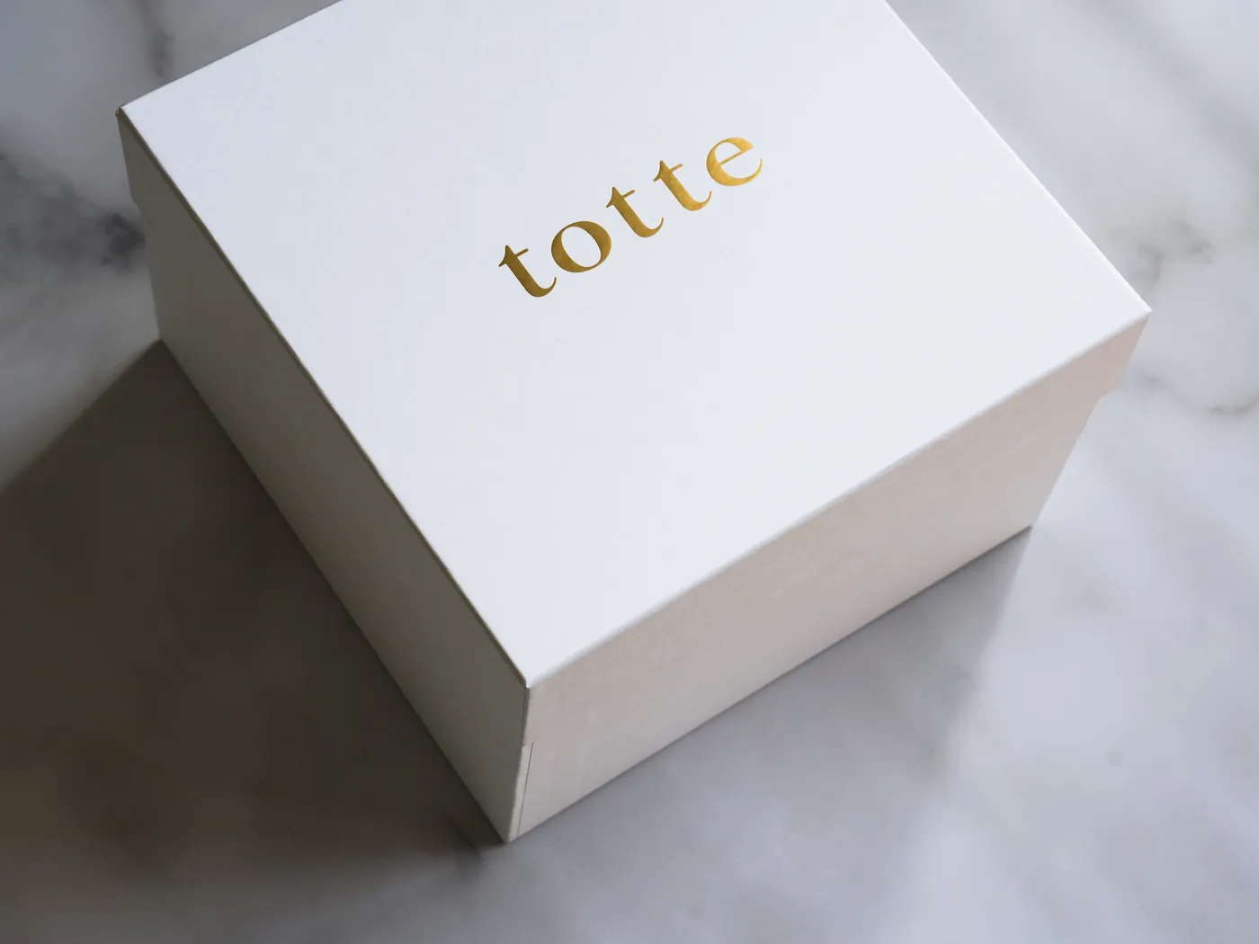 金色のtotteのロゴが入った、白いギフトボックス