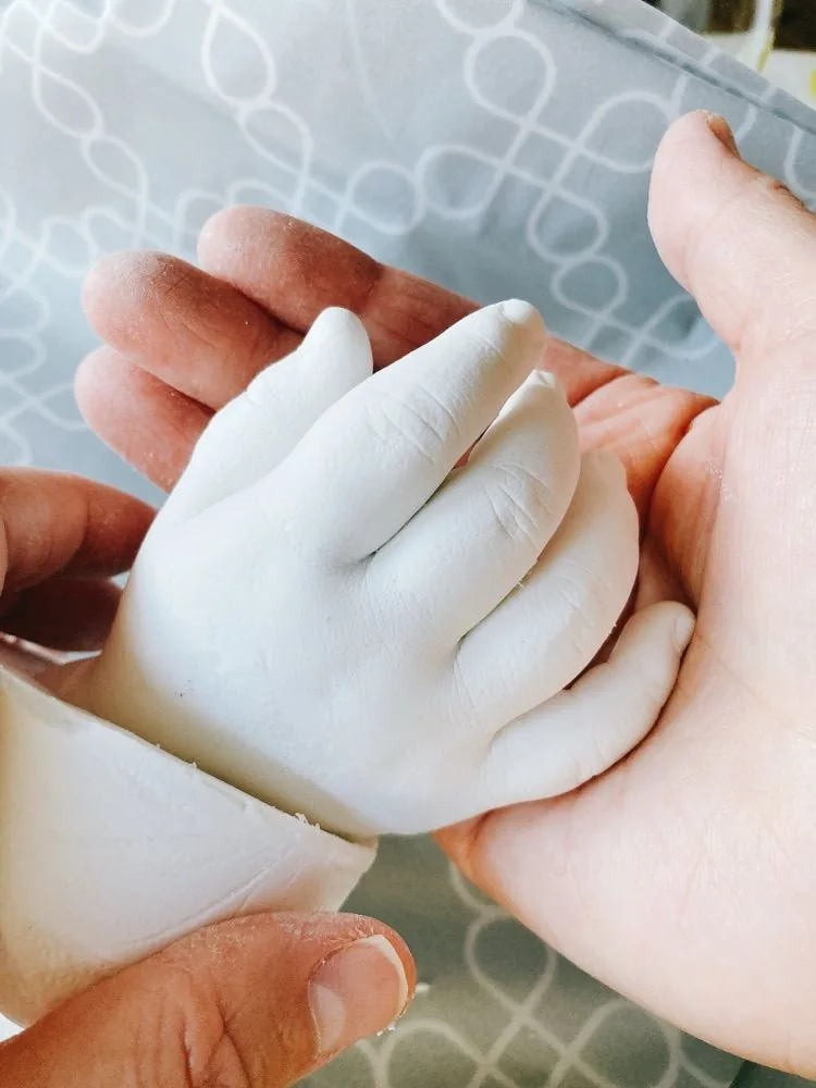 完成した赤ちゃんの手型を両手で包んでいる様子